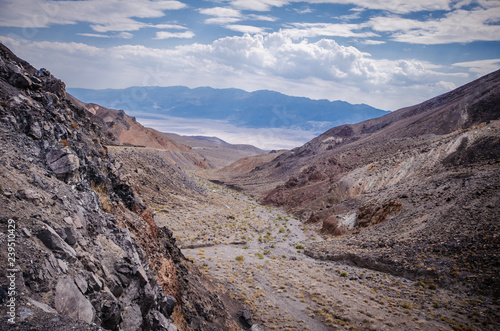 Valley and a desert wash filled with rocks, sand and sagebrush in Death Valley National Park in California