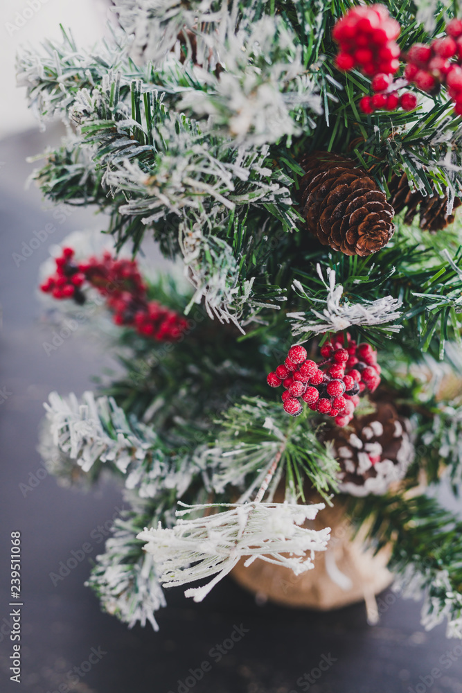 Christmas tree with pine cones and mistletoes berries and hints of snow on the branches