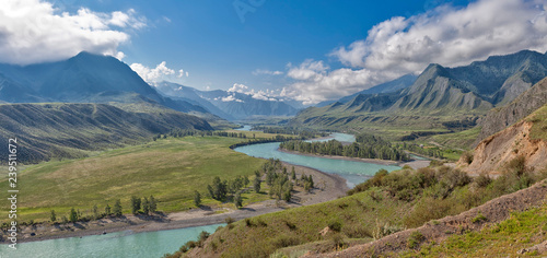 panorama of the summer landscape in the mountains. The valley of the mountain river Katun turquoise. the river flows between mountains and wide fields. blue sky and clouds view from high point