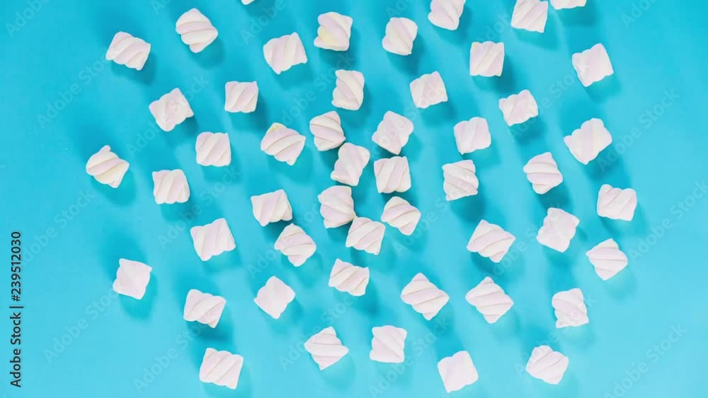 Marshmallow lie on a blue background and gather in a pile. Stop motion animation. Marshmallow lie on a blue background and gather in a pile. Stop motion animation.
