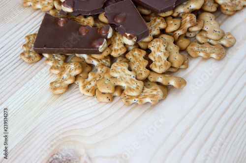chocolate with nuts and biscuits with poppy on wooden background