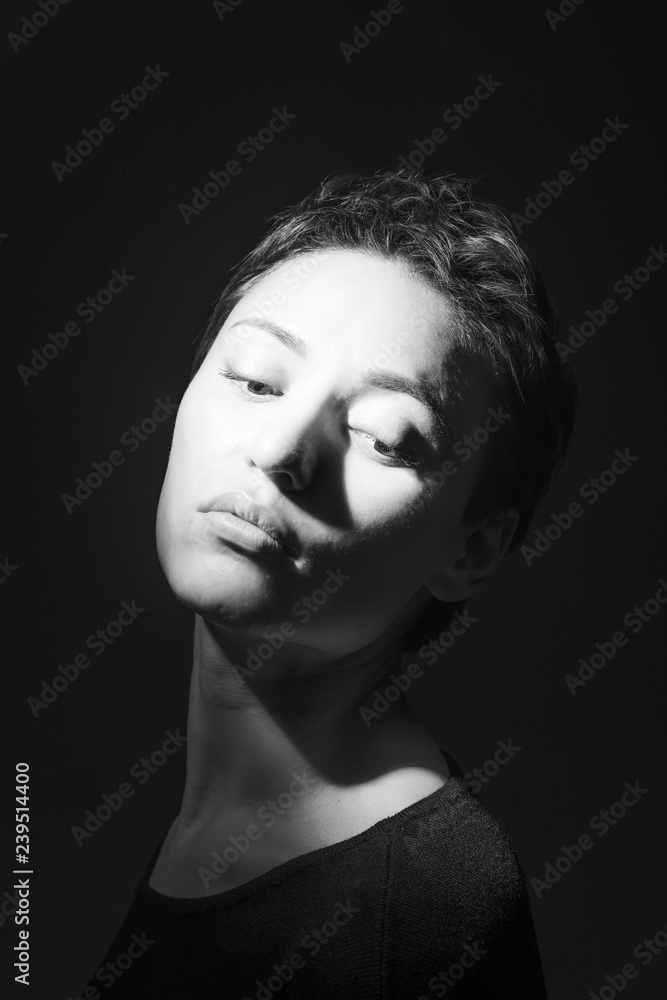 portrait of beautiful sensual woman looking down on dark background 