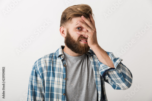 Ashamed bearded man dressed in plaid shirt