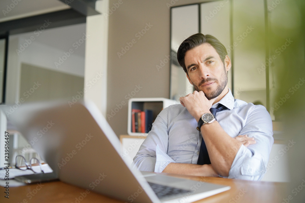 Relaxed attractive businessman working in modern office Relaxed attractive businessman working in modern office