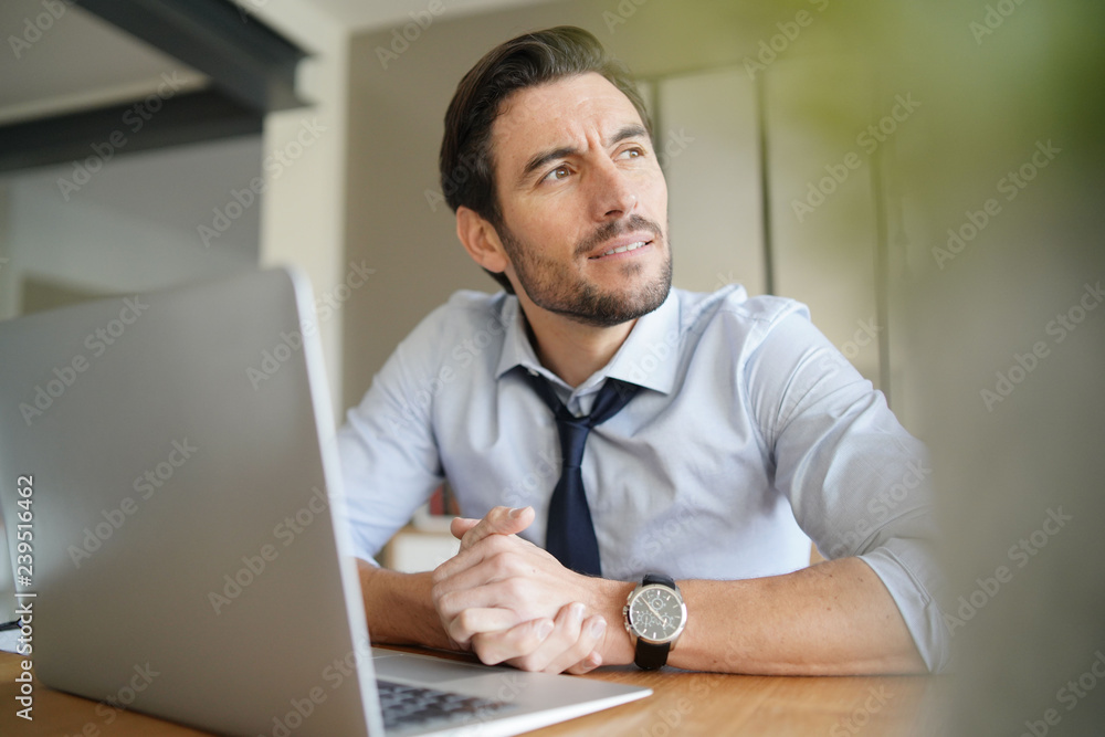 Relaxed attractive businessman working in modern office