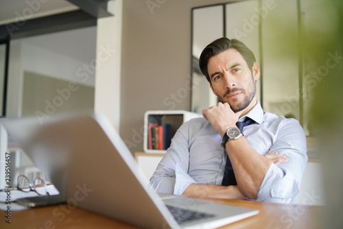 Relaxed attractive businessman working in modern office