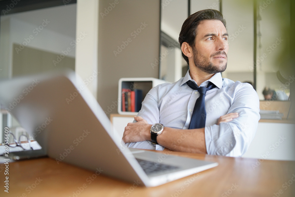 Relaxed attractive businessman working in modern office Relaxed attractive businessman working in modern office