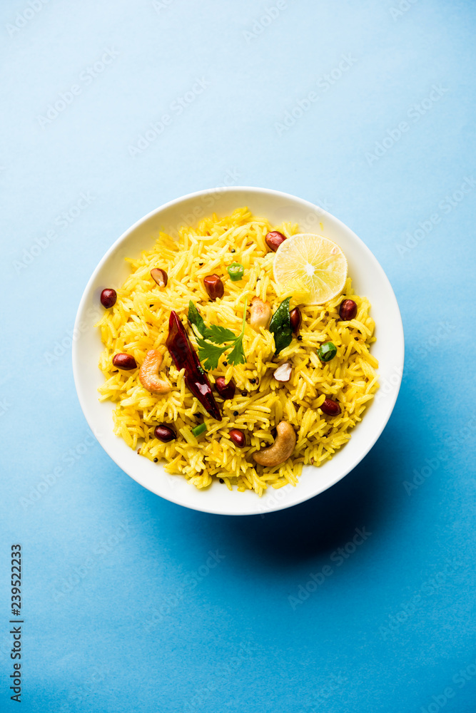 Lemon Rice is a South Indian turmeric rice or maharashtrian recipe called fodnicha bhat using leftover rice garnished with nuts curry leaves and lemon juice, selective focus Lemon Rice is a South Indian turmeric rice or maharashtrian recipe called fodnicha bhat using leftover rice garnished with nuts curry leaves and lemon juice, selective focus