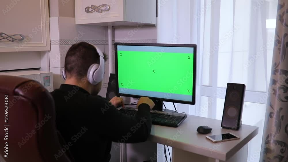 Man using PC computer with green screen chroma key at home Man using PC computer with green screen chroma key at home