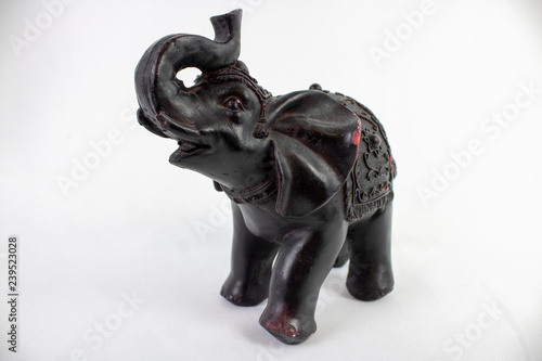 Black Ceramic Elephant ornament on a white background, elephant carving with his truck in the air.