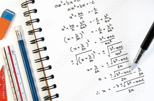 Handwriting of mathematics quadratic equation formula on examination, practice, quiz or test in maths class. Solving exponential equations background concept. photo
