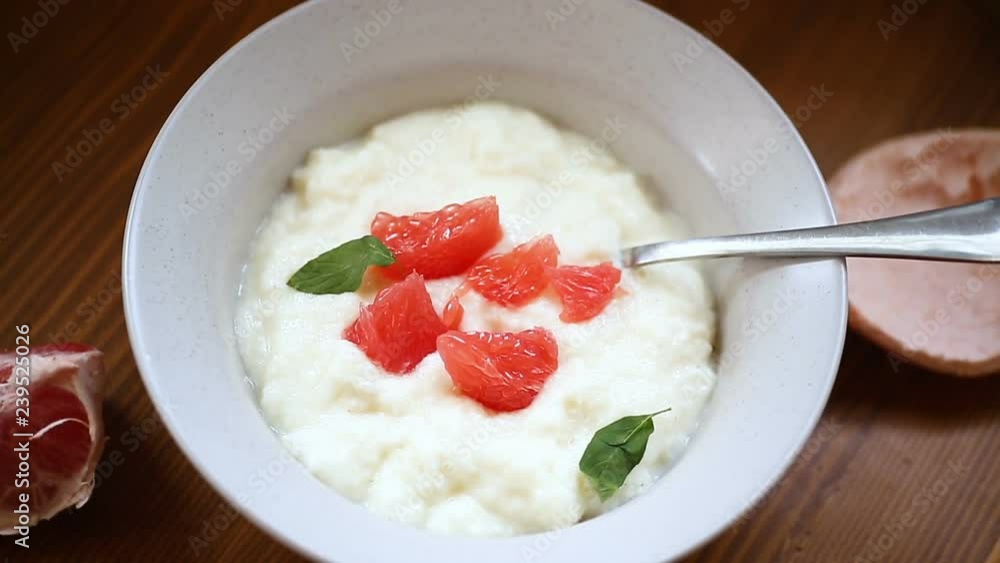 sweet boiled semolina porridge in a plate with slices of red grapefruit sweet boiled semolina porridge in a plate with slices of red grapefruit