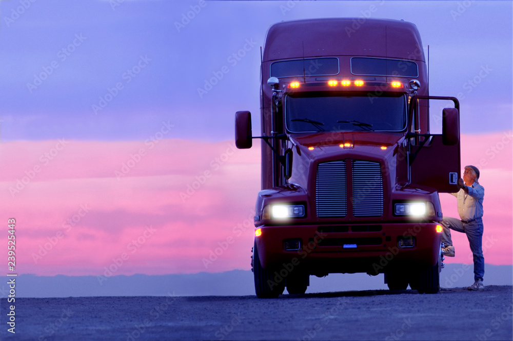 A silhouette of a truck driver getting into the cab of his commercial Class 8 truck tractor at sunrise. A silhouette of a truck driver getting into the cab of his commercial Class 8 truck tractor at sunrise.