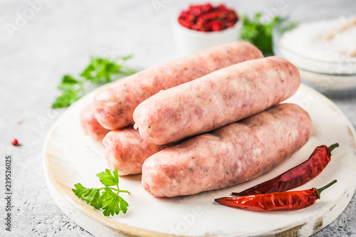 Raw sausages with spices, herbs. Selective focus, space for text.