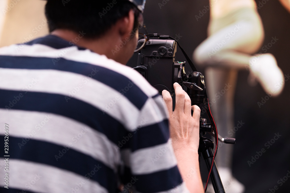 Photographer shooting model in studio,Photographer working on DSLR camera,camera on tripod in photo studio,professional photographer Photographer shooting model in studio,Photographer working on DSLR camera,camera on tripod in photo studio,professional photographer