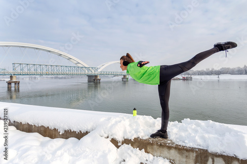 Young woman exercise on the show with bridge on background photo