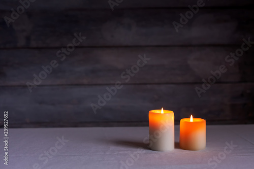 Two thick candles front view with rustic wood background