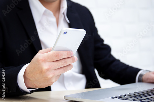Business man using a smartphones in the office close up. Digital and modern office life style concept.