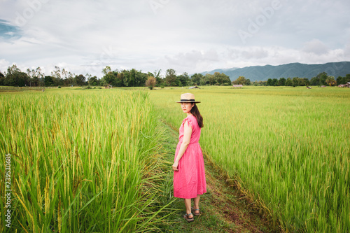 Portrait of beautiful Asian girl in vintage dress walking in the rice field. Processed in vintage color tone.