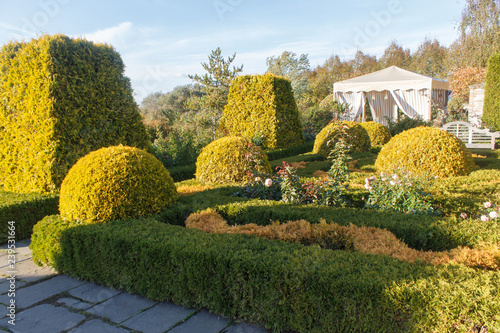 Cottage garden with topiary and trimmed bushes.