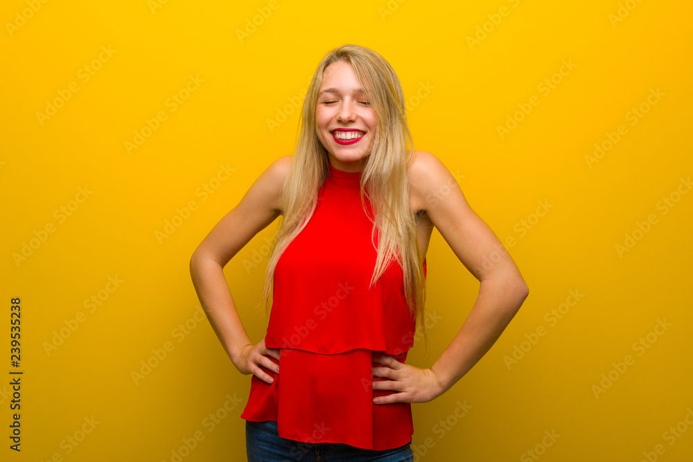 Young girl with red dress over yellow wall happy and smiling Young girl with red dress over yellow wall happy and smiling