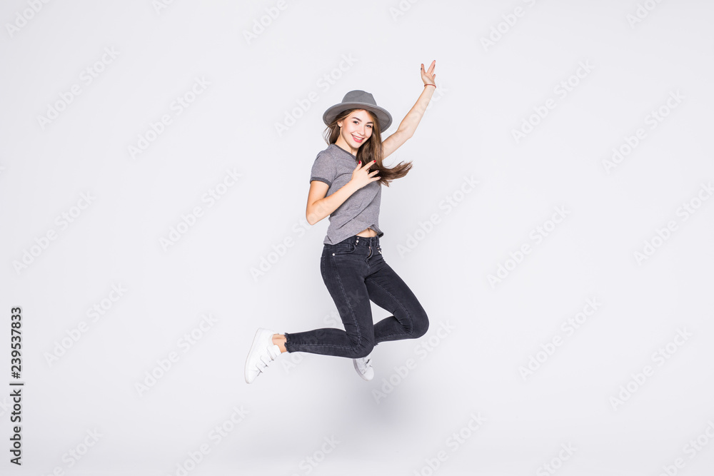 Attractive beautiful young girl wearing casual flying in air isolated over grey background