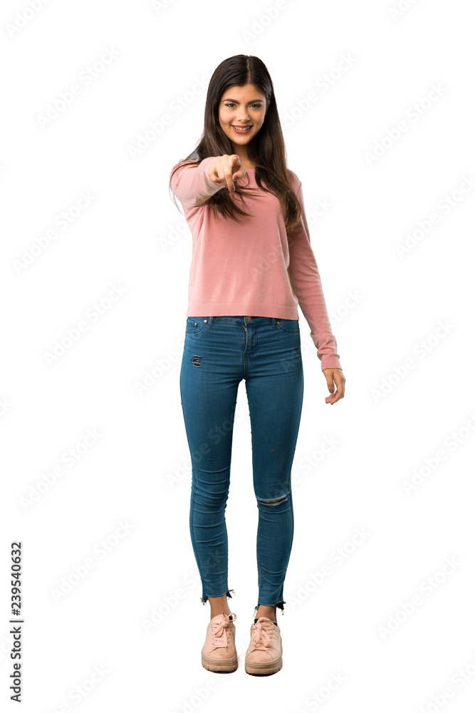A full-length shot of a Teenager girl with pink shirt points finger at you with a confident expression A full-length shot of a Teenager girl with pink shirt points finger at you with a confident expression