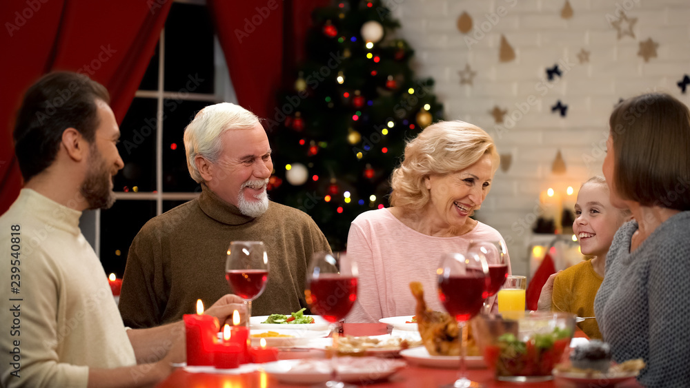 Family laughing sincerely during Christmas dinner, traditions and togetherness Family laughing sincerely during Christmas dinner, traditions and togetherness