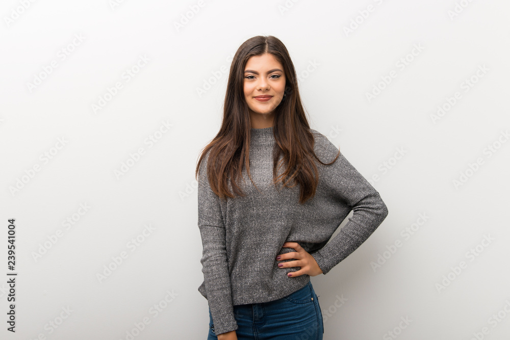 Teenager girl on isolated white backgorund posing with arms at hip and smiling Teenager girl on isolated white backgorund posing with arms at hip and smiling
