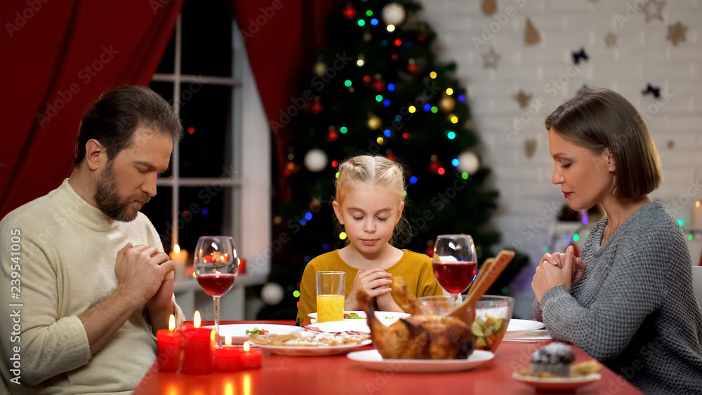 Traditional family praying before Xmas dinner, belief in god, Christianity Traditional family praying before Xmas dinner, belief in god, Christianity