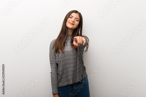 Teenager girl on isolated white backgorund points finger at you with a confident expression