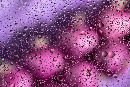 water drops on glass with orange and pink background  close-up 