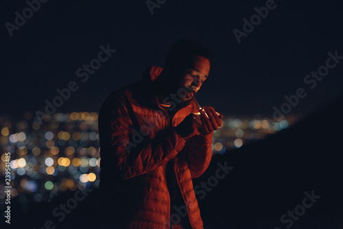Cinematic shot of man lighting a cigarette photo