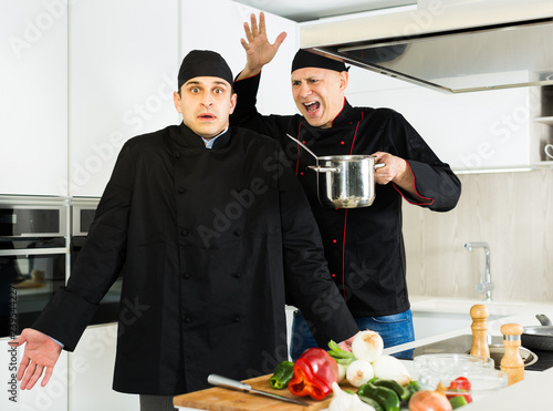 Men professionals are cooking salad with emotions in the kitchen
