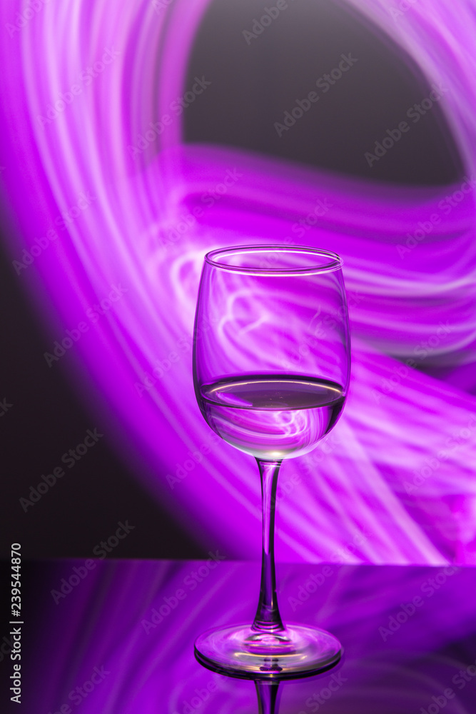 Drink at bar in a night time, wine glass with white wine and freeze light on a background. New year party drink.