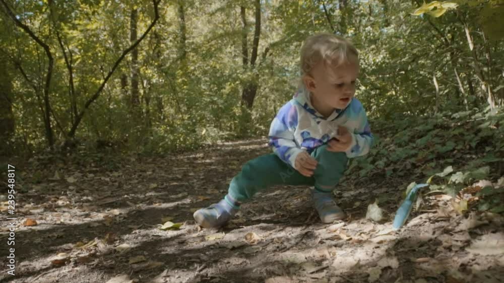 Cute Kid playing with whale toy in forest Cute Kid playing with whale toy in forest