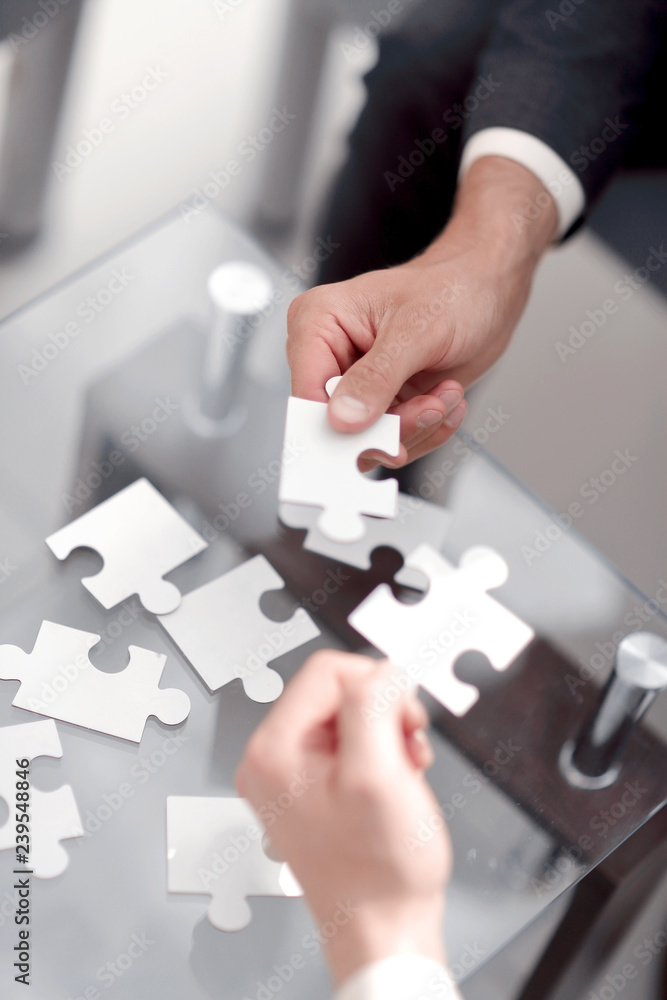 business partners put the pieces of the puzzle. business partners put the pieces of the puzzle.
