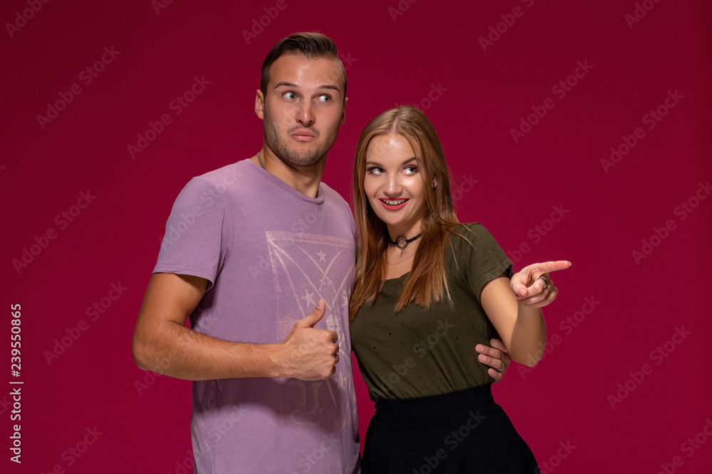 Obraz premium People, friendship, love and leisure concept - lovely couple with thumbs-up gesture on burgundy background