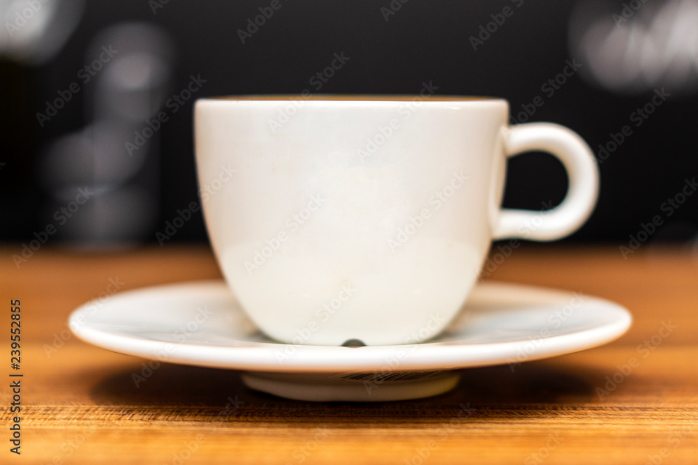 Fototapeta premium Coffee cup on wooden table with bokeh background