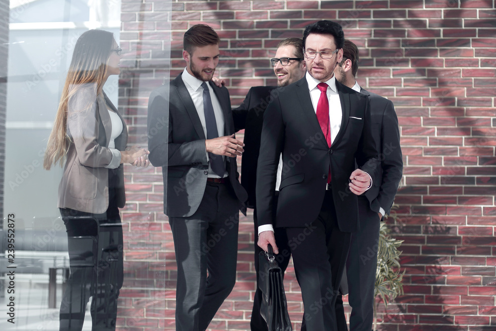 businessman and his team walking down the office corridor businessman and his team walking down the office corridor