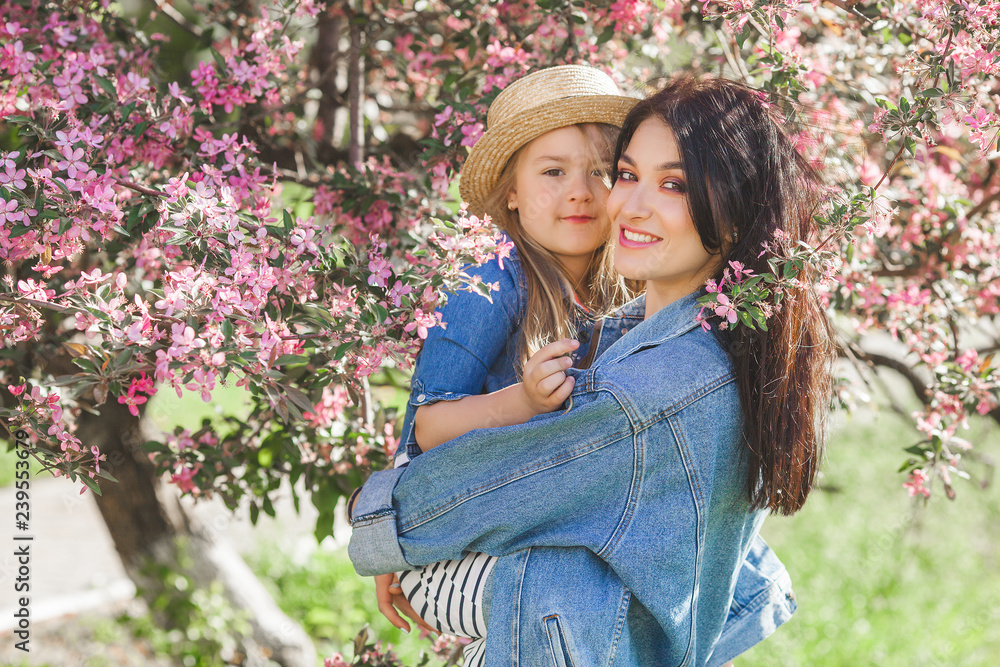 Young mother and her little daughter having fun in spring time. Beautiful mum and cute girl walking outdoor. Happy family together Young mother and her little daughter having fun in spring time. Beautiful mum and cute girl walking outdoor. Happy family together