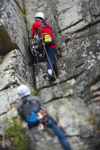 Two rock climbers work with a rope on the route. Tilt-Shift effect. © esalienko