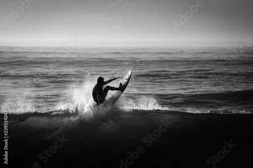 silueta de un surfista en blanco y negro y a contraluz	