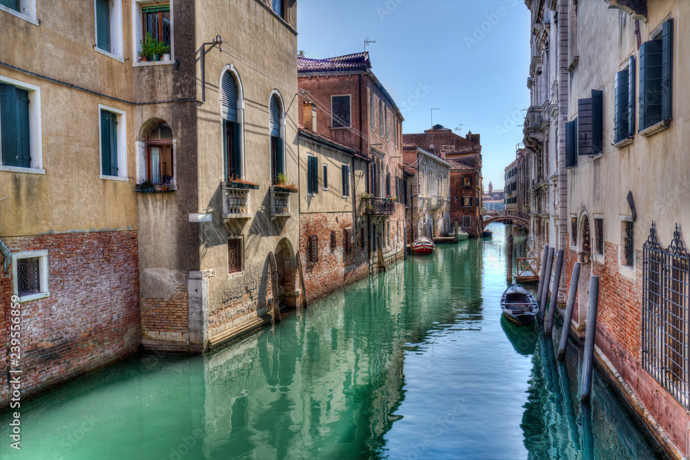 Narrow canal with small boats in Venice, Italy Narrow canal with small boats in Venice, Italy