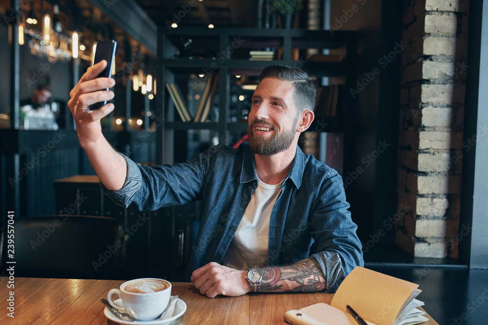 Man looking into the camera while making a selfie Man looking into the camera while making a selfie