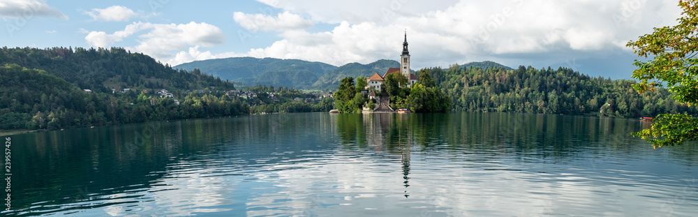 Very large panoramic view on The Church of Mary the Queen, aka the Pilgrimage Church of the Assumption of Mary, located on an island in Lake Bled
