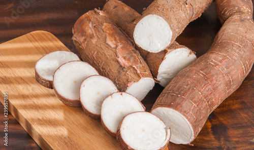 Raw cassava tuber on wooden background - Manihot esculenta