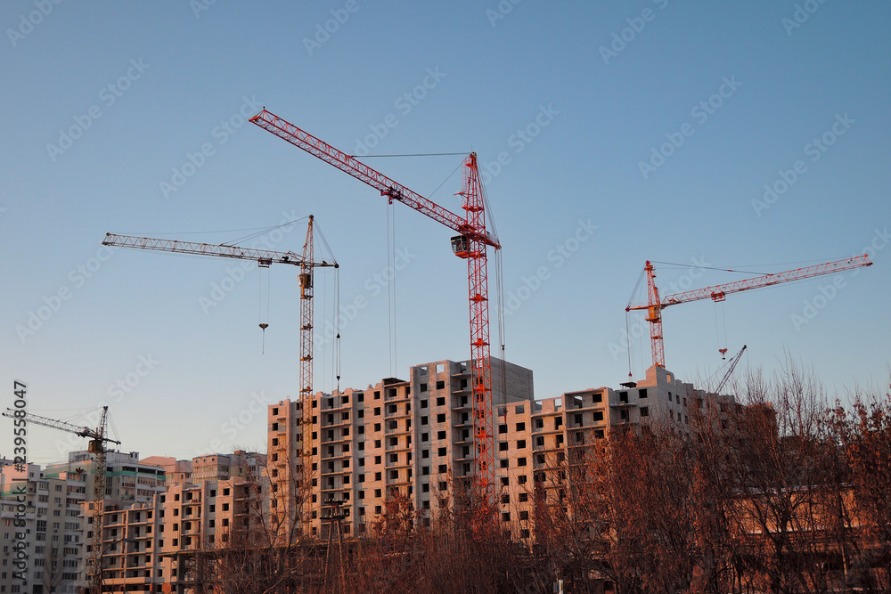 Industrial landscape at sunset. cranes build house. Industrial landscape at sunset. cranes build house.