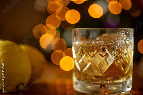 Canvas Print Glass of whiskey bourbon in a crystal glass up close shot Bokeh lights backgroun