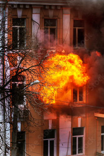 Odessa, Ukraine - Dec. 29, 2016: fire in an apartment building. Strong bright light and clubs, smoke clouds window of their burning house. Firefighters extinguish fire in house. Work on fire stairs